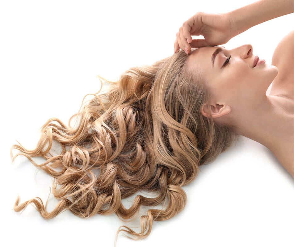 blonde woman with closed eyes lying down with her hair extended